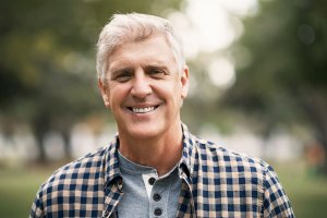 man standing outside, smiling