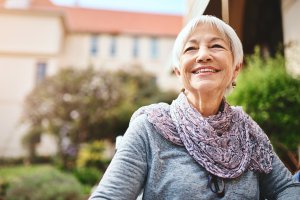 An older woman smiles outside