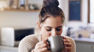 young woman drinking out of a mug